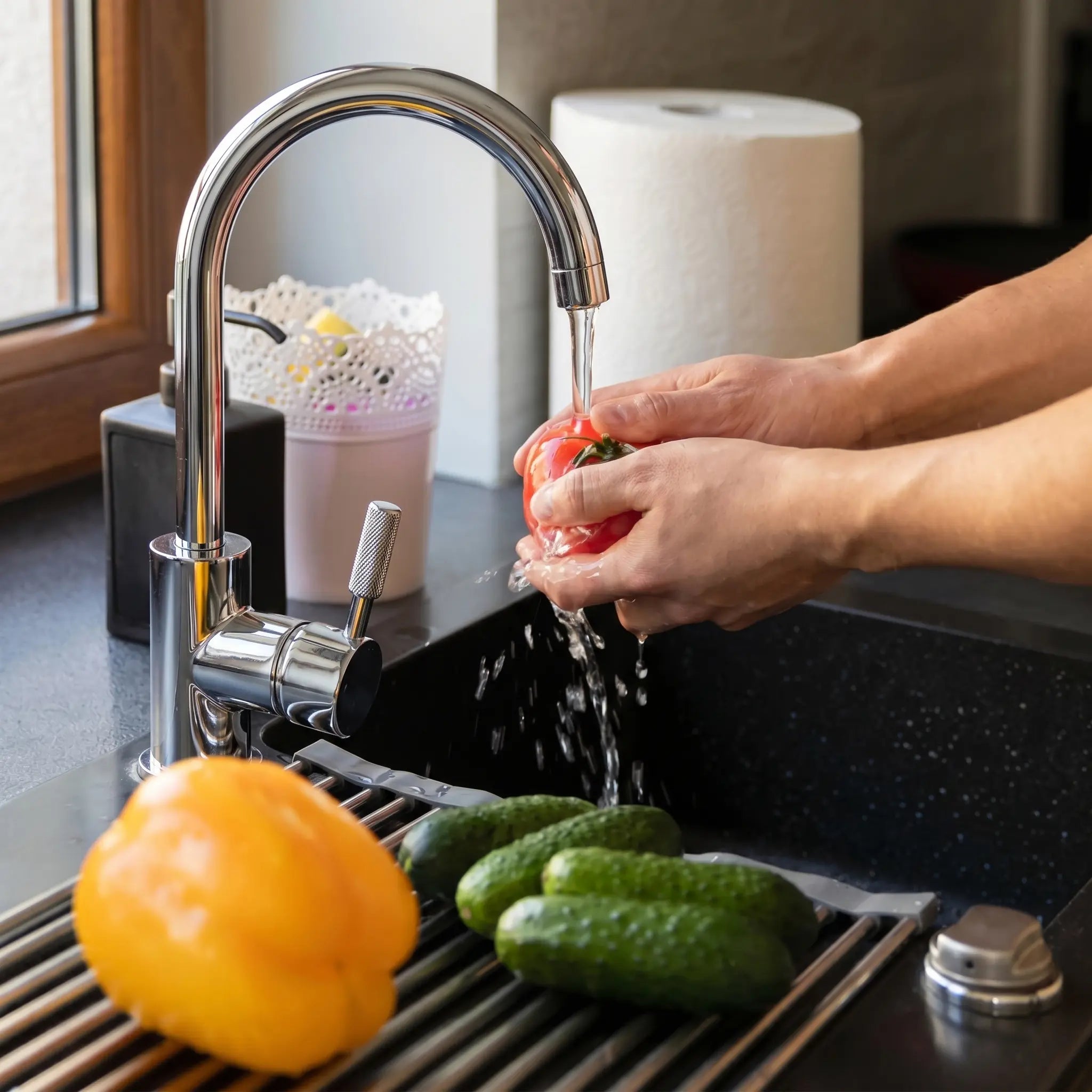 Hands washing vegetables under RO water tap